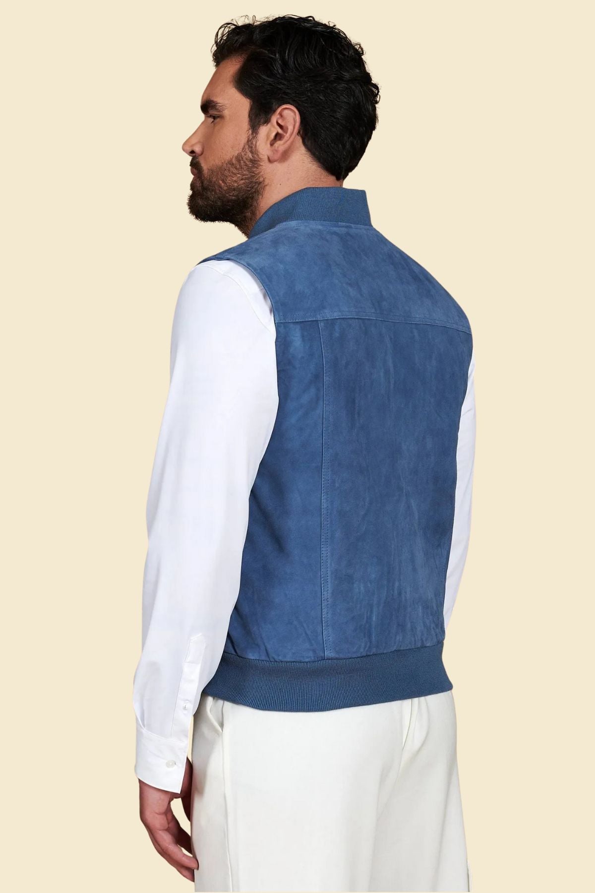 Close-up of premium blue suede leather texture and silver zipper detail on bomber vest.