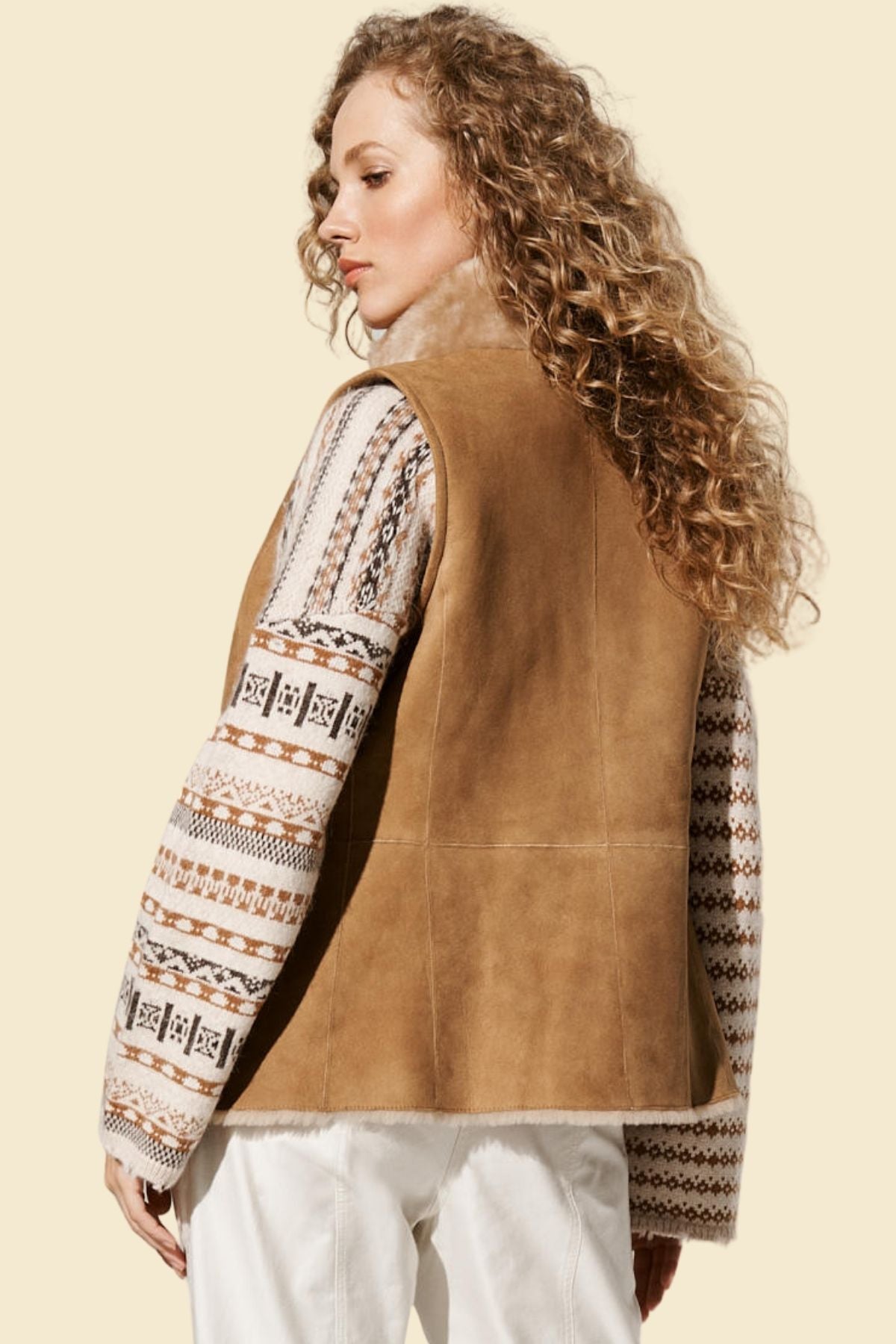Close-up of plush faux fur lining inside a brown leather vest for women.