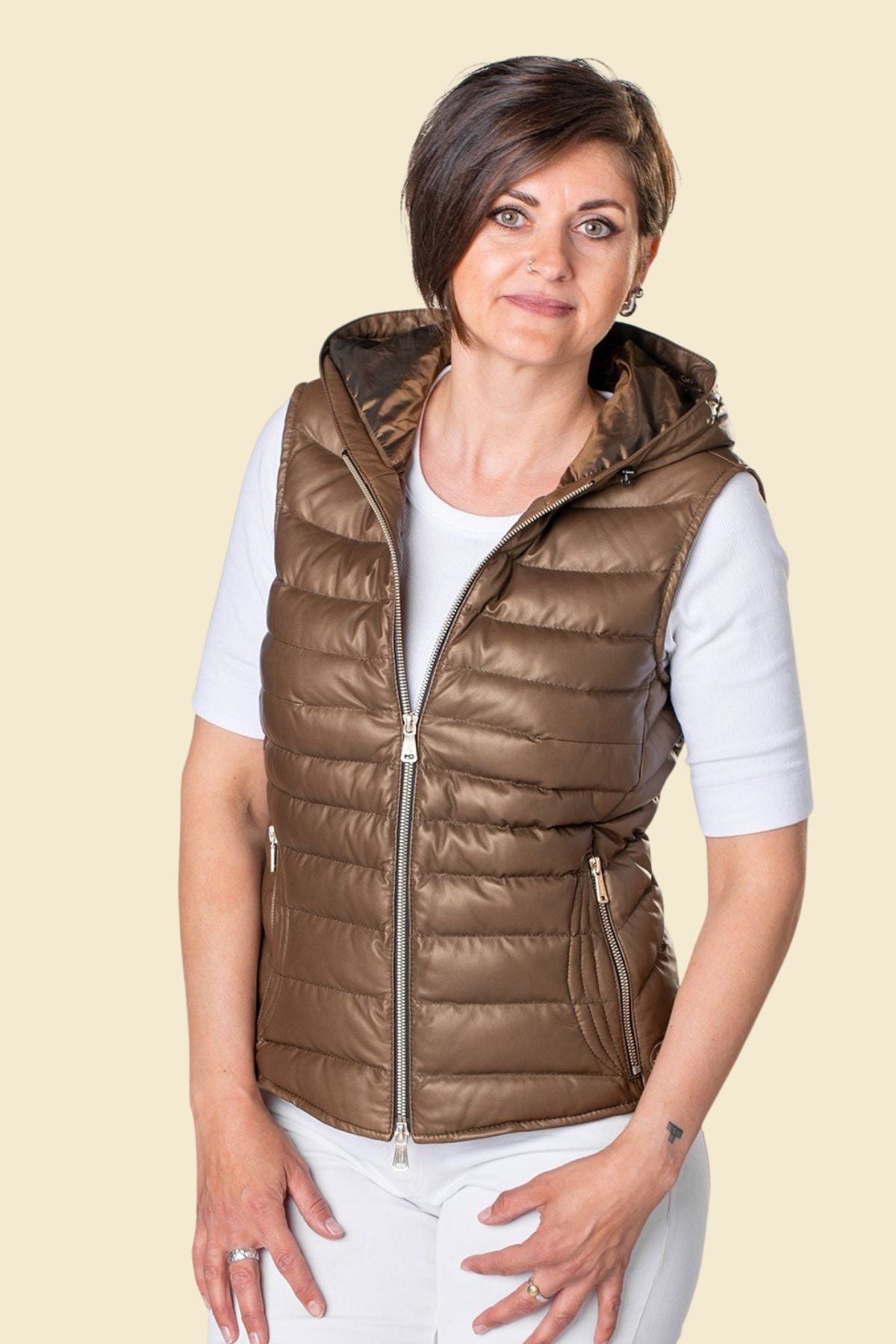 Women’s brown genuine leather puffer vest with hood and zip closure.