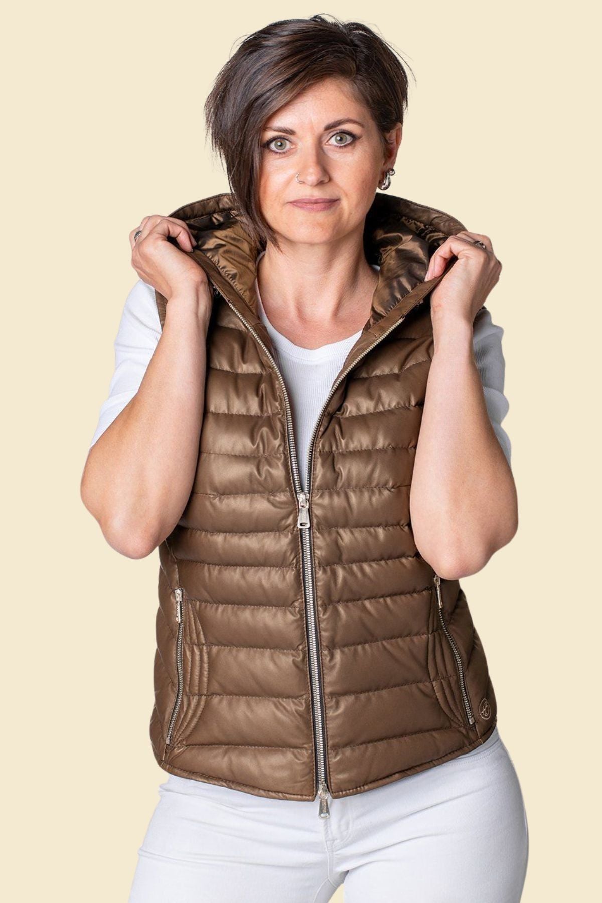 Warm and lightweight women’s leather puffer vest with quilted body and hood.