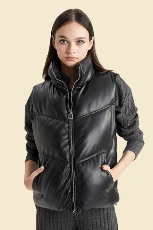 Plus size women’s black leather puffer vest with zip front and quilted design.